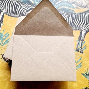May include: A brown paper envelope with a white interior. The envelope is folded and ready to be sealed.