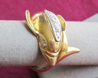 May include: A gold ring featuring a dolphin design with small diamonds set in the dolphin's fin.