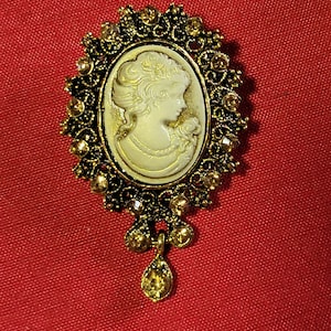 Gold tone cameo brooch pin with round topaz colored bling stones