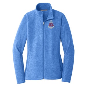 May include: A heathered blue full-zip jacket with a mock neck collar. The front features an embroidered white anchor graphic on the left chest, overlaid with a red three-letter monogram in a cursive script font. The jacket has long sleeves.