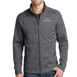 May include: A charcoal grey heathered full-zip jacket with a stand-up collar, long sleeves, and three zippered pockets. The left chest features a white graphic of eyeglasses above the text "Joseph D Smith, OD" in a clean, sans-serif font.