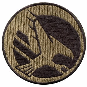 May include: A round, tan-colored patch with a black embroidered silhouette of a horse's head inside a circle.