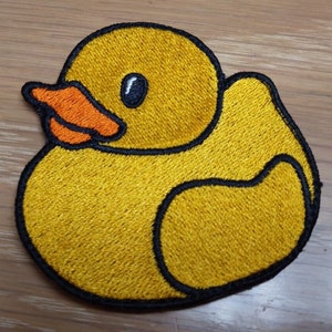 May include: Yellow rubber ducky embroidered patch with black outline and orange beak.