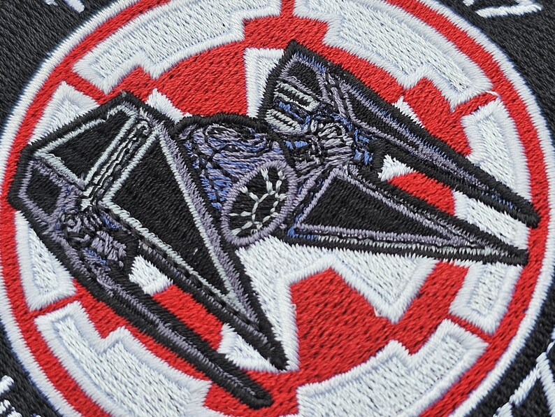 May include: A black and gray TIE fighter embroidered patch with a red and white Rebel Alliance symbol in the background.