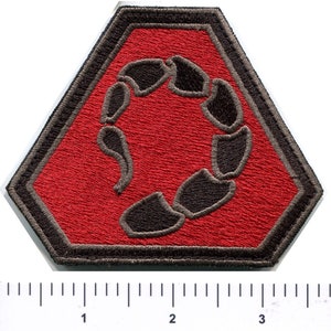 Op de afbeelding: Een geborduurde patch in rood en zwart met een schorpioenontwerp. De schorpioen is opgerold tot een cirkel en is zwart omrand. De patch heeft de vorm van een zeshoek met afgeronde hoeken.