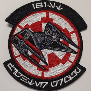 Puede incluir: Un parche bordado negro y rojo con una silueta de caza TIE y el texto "181st TIE Squadron" en blanco.