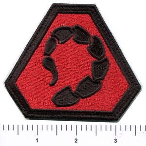 Op de afbeelding: Een rode zeshoekige patch met een zwart geborduurd schorpioendesign. De schorpioen is opgerold in een cirkelvorm.