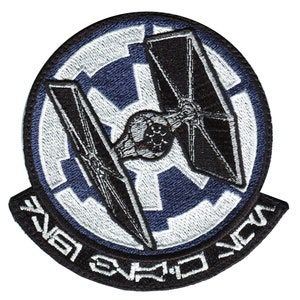 Op de afbeelding: Een geborduurde patch in zwart en wit met een TIE-jager tegen een blauwe en witte keizerlijke symbool. De tekst "TIE Fighter Squadron" is in zwart rond de rand van de patch geschreven.