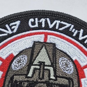 May include: A black and red embroidered patch with a stylized image of a helmet and the text "1/57th CHIMERA".