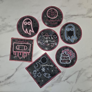 May include: Set of nine embroidered iron-on patches with various designs and text, including "Come Home", "Melancholy Youth", "There is Still Time", "Starburned", and "I Saw The Future Glow".