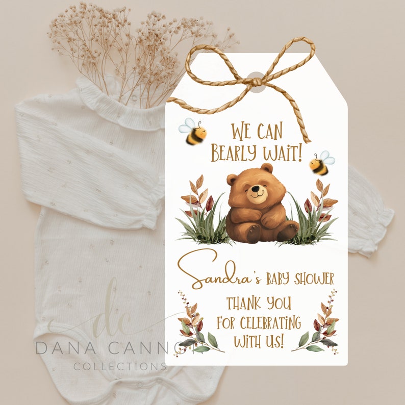 May include: A white thank you tag with a brown bear and bees. The text reads "We can bearly wait!" and "Sandra's Baby Shower Thank You for Celebrating with Us!"