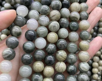 May include: A strand of round, green and white gemstone beads. The beads have a mottled, marbled appearance.