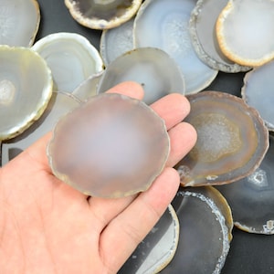 以下が含まれることがあります： 灰色と茶色の様々な色合いのアゲートのスライスを集めたものです。スライスは滑らかで磨かれており、自然で有機的な形をしています。クラフト、ジュエリー作り、または装飾的なアクセントとして使用するために最適です。