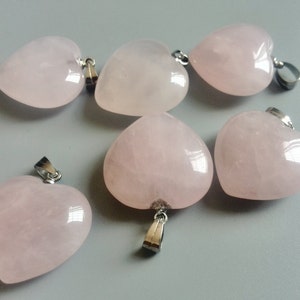 May include: Six pink heart-shaped pendants with silver bail loops. The pendants are made of rose quartz and are perfect for jewelry making.