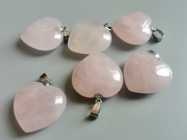 May include: Six pink heart-shaped pendants with silver bail loops. The pendants are made of rose quartz and are perfect for jewelry making.
