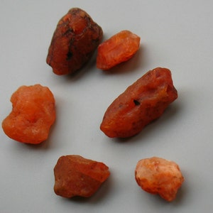 Puede incluir: Seis piedras de cornalina naranja de diferentes tamaños y formas. Las piedras son lisas y pulidas.