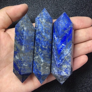 May include: Three blue lapis lazuli crystal points with white and grey veining. The points are double-terminated and have a smooth, polished finish.