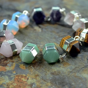 May include: A silver charm bracelet with various gemstone pendants, including amethyst, rose quartz, opal, green aventurine, and tiger's eye.