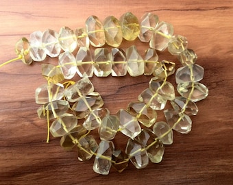 May include: A strand of faceted, light yellow citrine beads. The beads are strung on a thin yellow thread and are arranged in a loose, overlapping pattern.