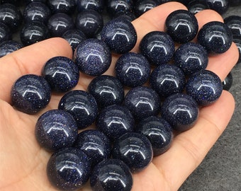 May include: A collection of blue sand stone spheres, also known as blue aventurine, in various sizes. The spheres are smooth and polished, with a speckled appearance.