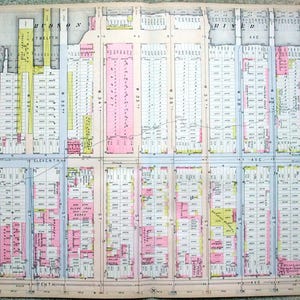 May include: A detailed vintage map of a city, featuring a grid layout with streets and numbered blocks. The map uses a color-coded system, with pink, yellow, and blue highlighting different areas. Text includes street names and the words "Hudson" and "River Ave."