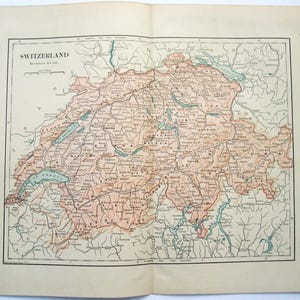 May include: Vintage map of Switzerland, featuring detailed geographical information. The map is printed on aged paper, with the title "Switzerland" at the top. The map includes lakes, rivers, and cities, with a color palette of brown, green, and blue.