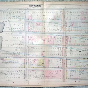 May include: Antique map of the 22nd Ward, featuring detailed street layouts, building outlines, and annotations. The map is printed on aged paper with faded colors, including pink and blue highlights, and includes street names and numbers.
