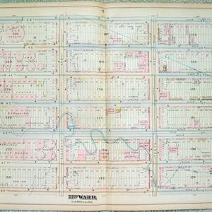 May include: A vintage map of a city, featuring a grid layout with streets and numbered blocks. The map is printed on aged paper with pink and blue highlights, and includes the text "22nd Ward".