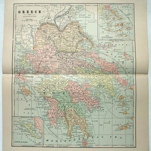 May include: A vintage map of Greece, featuring detailed geographical information. The map is divided into sections with various colors, including green, yellow, and pink, and includes the text "GREECE" at the top. The map is printed on aged paper.