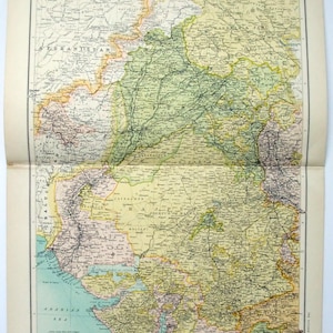 May include: A detailed vintage map of India, printed on aged paper. The map features a beige, green, and blue colour scheme, with the title "INDIA" at the top. It displays the country's borders, cities, and geographical features, offering a historical perspective.