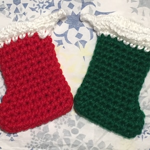 May include: Two crocheted Christmas stockings, one red and one green, with white crocheted tops.