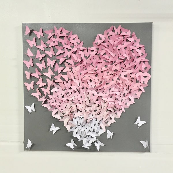 Quadro em tela com borboletas em formato de coração, decoração de quarto de bebê em degradê rosa.