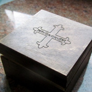 May include: A wooden box with a cross design and the words "In Sacrum" engraved on the top.