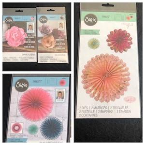 May include: A set of three die-cut paper flower designs. The flowers are pink, blue, and green with intricate lace-like edges. The packaging includes the text "Thinlits" and "David Tutera".