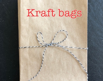 May include: A stack of brown kraft paper bags tied together with black and white twine. The bags are labeled "Kraft bags" in red text.