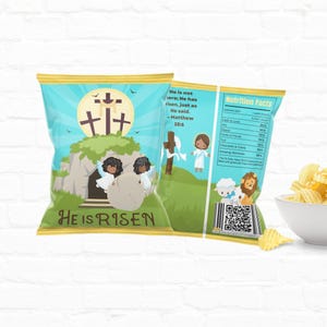 May include: A blue and green chip bag with a cartoon illustration of a tomb with two angels rolling a stone away. The bag has the text "He is Risen" and a quote from Matthew 28:6. The back of the bag has a nutrition facts label and a QR code.