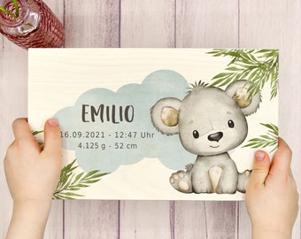 Könnte beinhalten: Eine Holzplakette mit einer hellblauen Wolke und einer niedlichen Illustration eines grauen Koalabären. Die Plakette trägt den Namen "Emilio" und das Datum "16.09.2021 - 12:47 Uhr" mit dem Gewicht "4,125 g" und der Größe "52 cm" darauf.