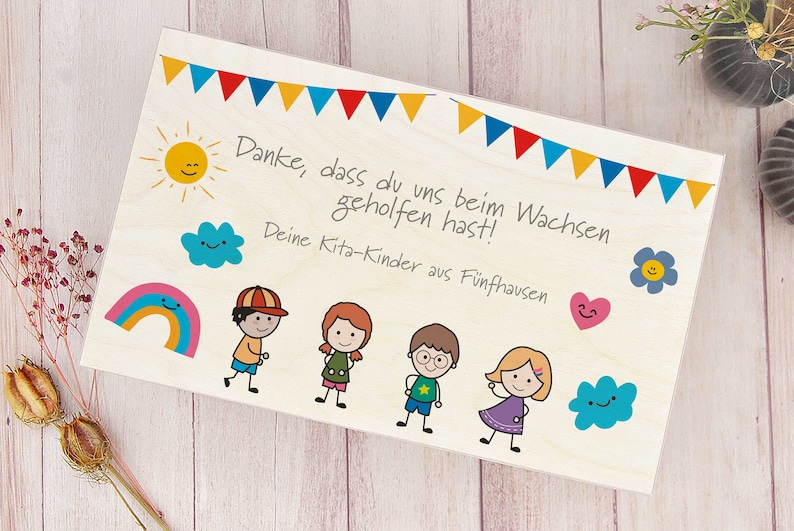 K&ouml;nnte beinhalten: Eine Holz-Dankeskarte mit einer bunten Girlande, einem Regenbogen, einer Sonne, Wolken und einem Herz. Die Karte sagt "Danke, dass du uns beim Wachsen geholfen hast! Deine Kita-Kinder aus F&uuml;nfhausen".