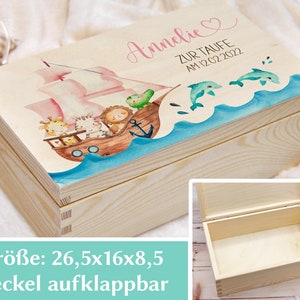 May include: A wooden box with a hinged lid, decorated with a watercolor illustration of a pink sailboat with animals on board, sailing on blue water with dolphins. The box is 26.5 inches by 16 inches by 8.5 inches and has the name "Annelie" and the text "Zur Taufe am 12.02.2022" on the lid.
