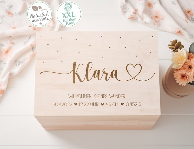 May include: A wooden keepsake box with a light wood finish. The box is engraved with the name "Klara" and the text "Willkommen kleines Wunder" (Welcome little wonder). The date, time, length, and weight are also engraved on the box: 14.01.2022, 12:22 Uhr, 46 cm, 3.452 g.