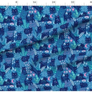 May include: A blue fabric with a repeating pattern of black cats, stars, moons, and flowers. The fabric is perfect for crafting projects, quilting, and home decor.