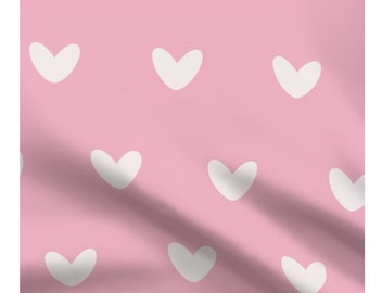 May include: A pink fabric with a repeating pattern of white hearts.