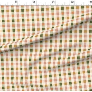 May include: A white fabric with a checkered pattern in shades of pink, green, and brown. The fabric is folded in the center.
