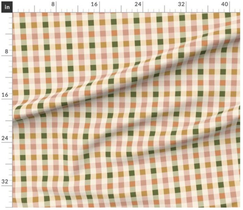 May include: A white fabric with a checkered pattern in shades of pink, green, and brown. The fabric is folded in the center.