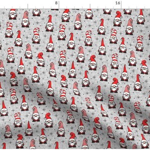 Puede incluir: Una tela gris con un patr&oacute;n repetido de gnomos rojos y blancos con barbas blancas y sombreros rojos. El fondo es gris claro con una textura sutil.
