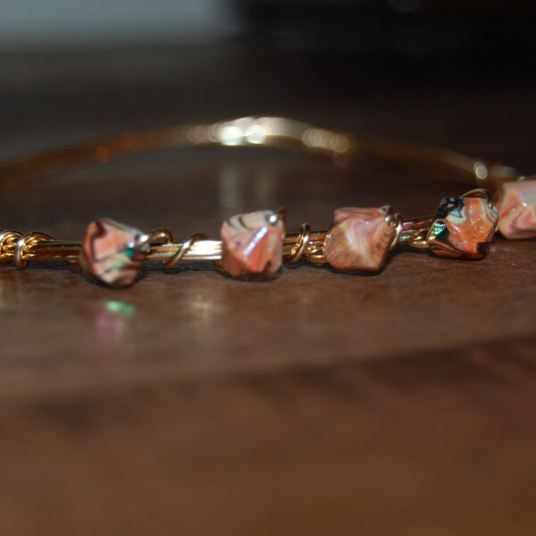 Wire wrapped beaded bracelet, gold with peach/black beads