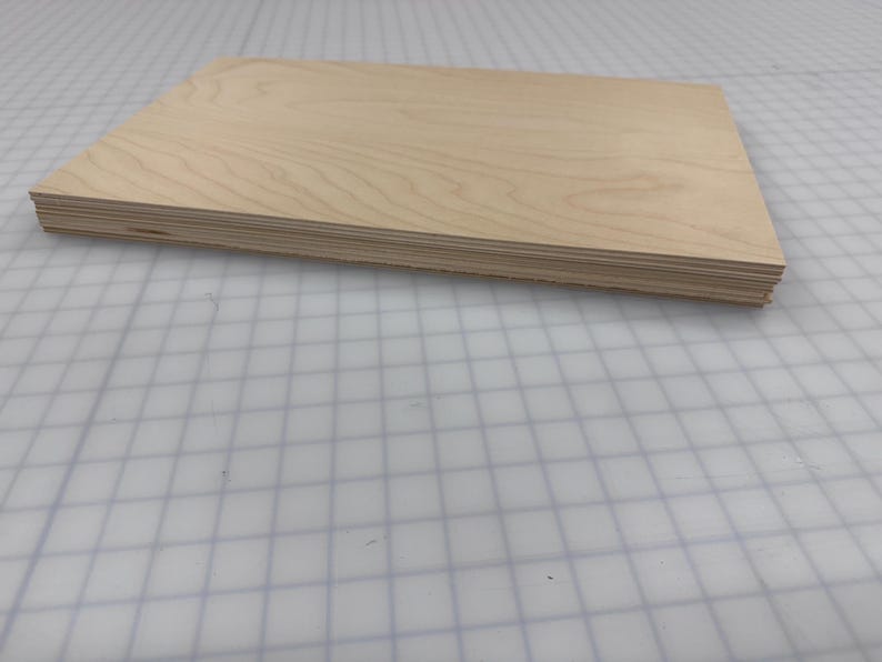 Puede incluir: Una pila de finas l&aacute;minas de madera clara, probablemente contrachapado, con un acabado de veta de madera natural.