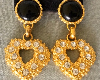 May include: Gold tone heart-shaped dangle earrings with clear rhinestone accents and black cabochon tops.