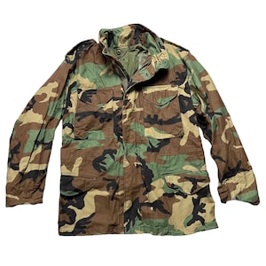 May include: A green, brown, and black camouflage jacket with a zipper and button closure.