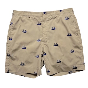 May include: Beige shorts with a blue and white island pattern.